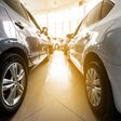Autos stehen im Autohaus, Sonne scheint durch die Fenster des Autohauses