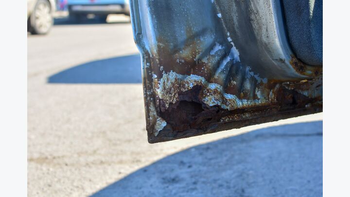 Fragment of a car with rust. fragment of a rusty car door.The car body element is corroded. Concept: corrosion resistant, car body repair, rust. Protection.