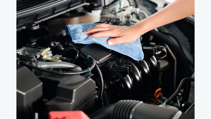 hand of a man holding a blue cloth caring, maintenance car and cleaning And engine car room.Hand focus selection
