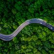 Forest Road, Aerial view over tropical tree forest with a road going through with car.
