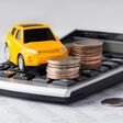 Car and coins on calculator, car loan, buying, leasing