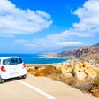 Rental car parked on road side during coastal drive around Karpathos island, Greece