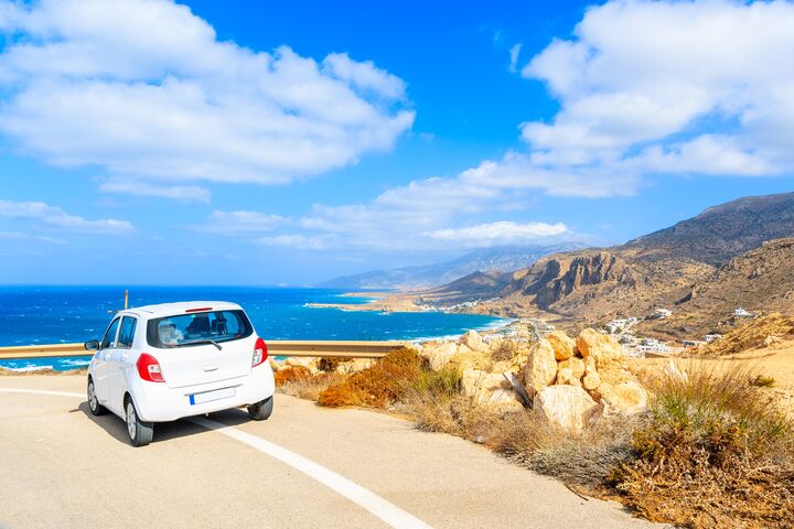 Rental car parked on road side during coastal drive around Karpathos island, Greece