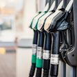 Closeup of woman pumping gasoline fuel in car at gas station. Petrol or gasoline being pumped into a motor. Transport concept
