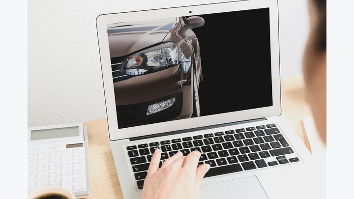 Buying online. Woman choosing car using laptop, closeup view