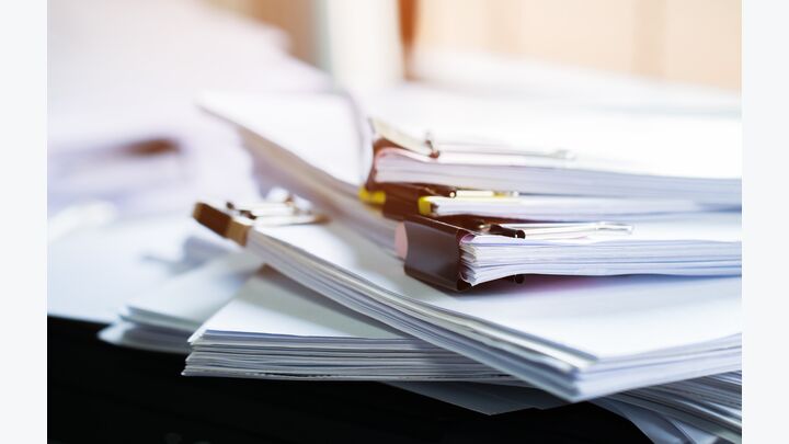 Stack of papers documents in archives files with clip papers on table at offices, Busy offices and Pile of data unfinished folders on office desk indoor near window, Business concept.