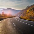 New empty highway in mountains in autumn evening. Road without cars.