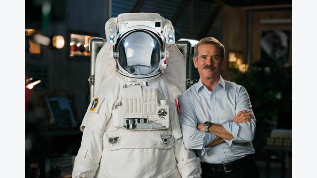 Astronaut Chris Hadfield neben einem Raumanzug