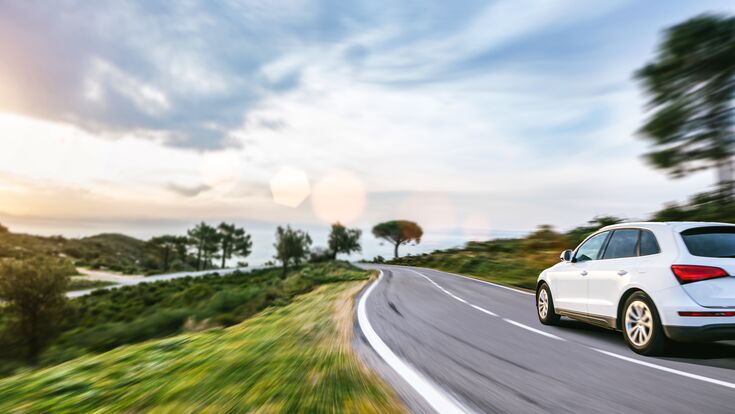 © AA+W - stock.adobe.com rental car in spain mountain landscape road at sunset. selective focus with motion blur effects