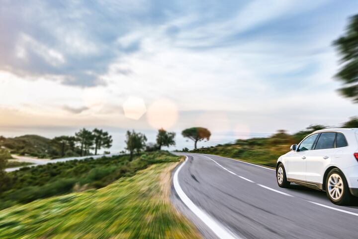 rental car in spain mountain landscape road at sunset. selective focus with motion blur effects