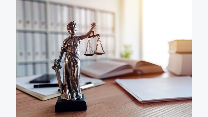 Lady Justice statue in law firm attorney office, blindfolded Justitia with balance scales and sword is personification of moral force in judicial system