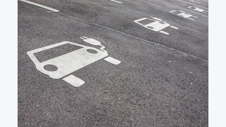 Symbol E-Autos auf Parkplatz bei Ladestation für Autostrom