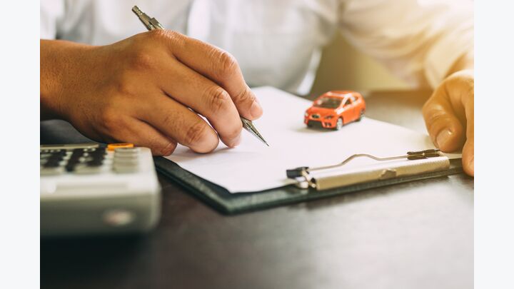 Businessman with car insurance contract and calculator.