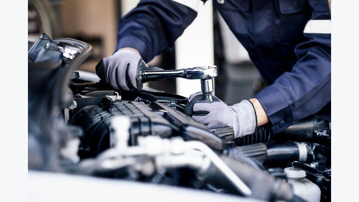 Professional mechanic working on the engine of the car in the garage. Car repair service. The concept of checking the readiness of the car before leaving.