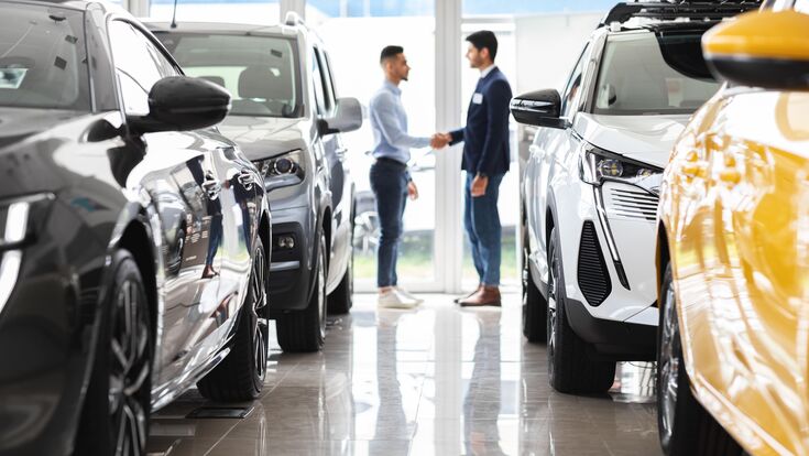 © Prostock-studio - stock.adobe.co Middle-eastern young man customer and sales assistant shaking hands, car showroom interior, friendly manager greeting wealthy arab guy, standing among luxury brand new autos, full size shot