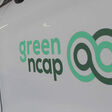 Weises Auto mit Green NCAP Logo auf der Seite in einer Werkstatt