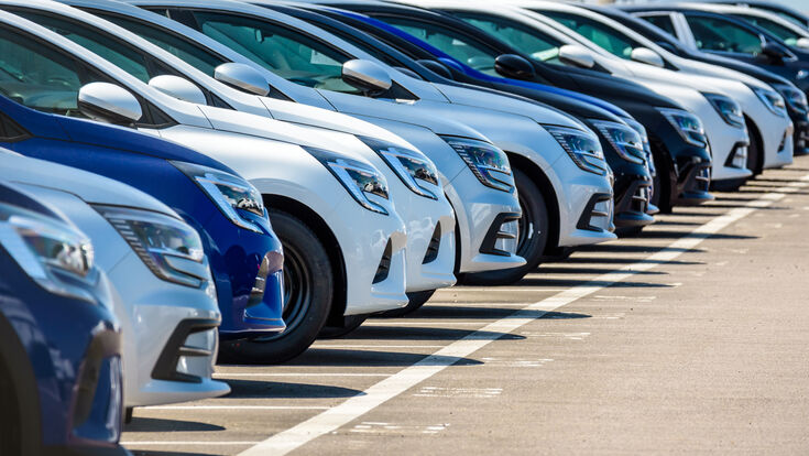 © olrat - stock.adobe.com car vehicle new brand row lined up front parking lot parked outdoors manufacturer maker automaker automotive automobile industry transport transportation trade business production factory port terminal sunlight sunny blue white gray black line vanishing point diagonal
