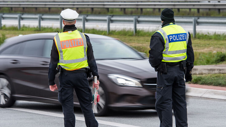 © benjaminnolte - stock.adobe.com polizei auto strasse beamte polizeibeamter schutz polizeikontrolle kontrolle kontrollieren polizist polizisten polizeibeamte einsatz anhalten prüfen überprüfen kontrollstelle sichern absichern absicherung warnweste sicherheitskräfte durchsuchen durchsuchung führerschein fahrzeugschein personenüberprüfung personenkontrolle fahrzeugkontrolle