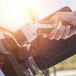 Color image of a man's hand preparing to charge an electric car.; Shutterstock ID 456984208