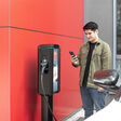 Mann mit Handy vor Ladestation