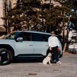 Valentin Bontus und flauschiger Vierbeiner vor dem Elektro-SUV Kia EV9.