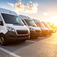 White delivery vans parked in a row at sunset